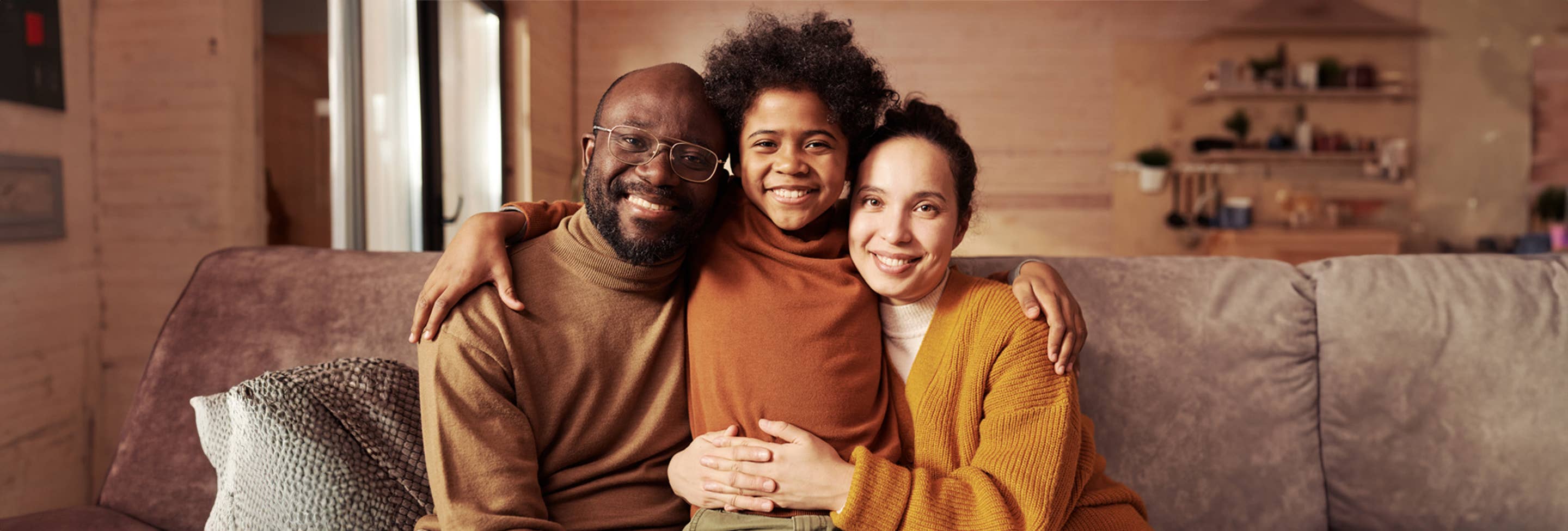 Family sitting on couch smiling