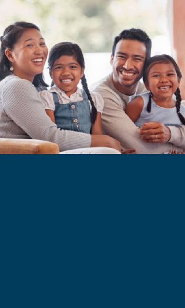 Family sitting on couch smiling