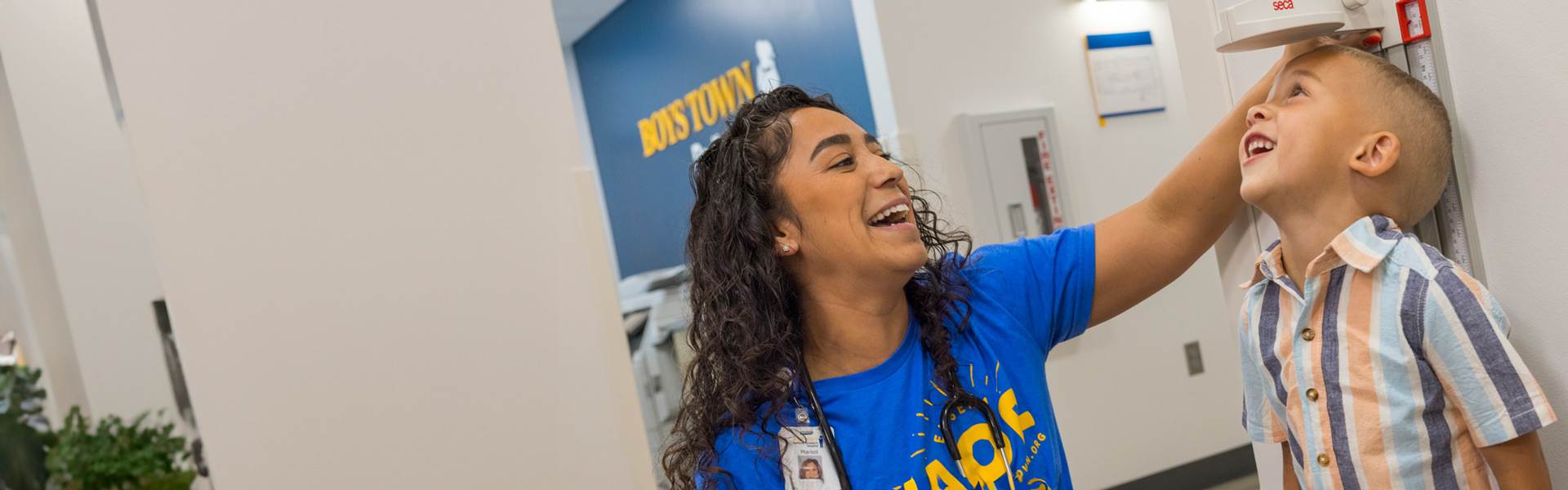 Nurse taking height measurement of young toddler