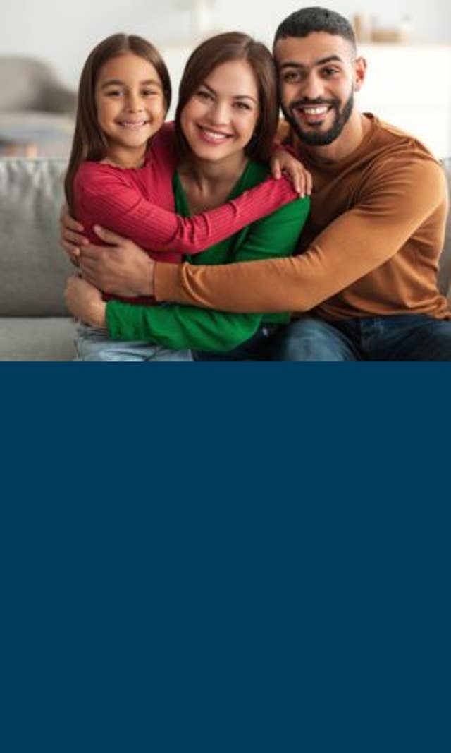 Family of three sitting on a couch. 