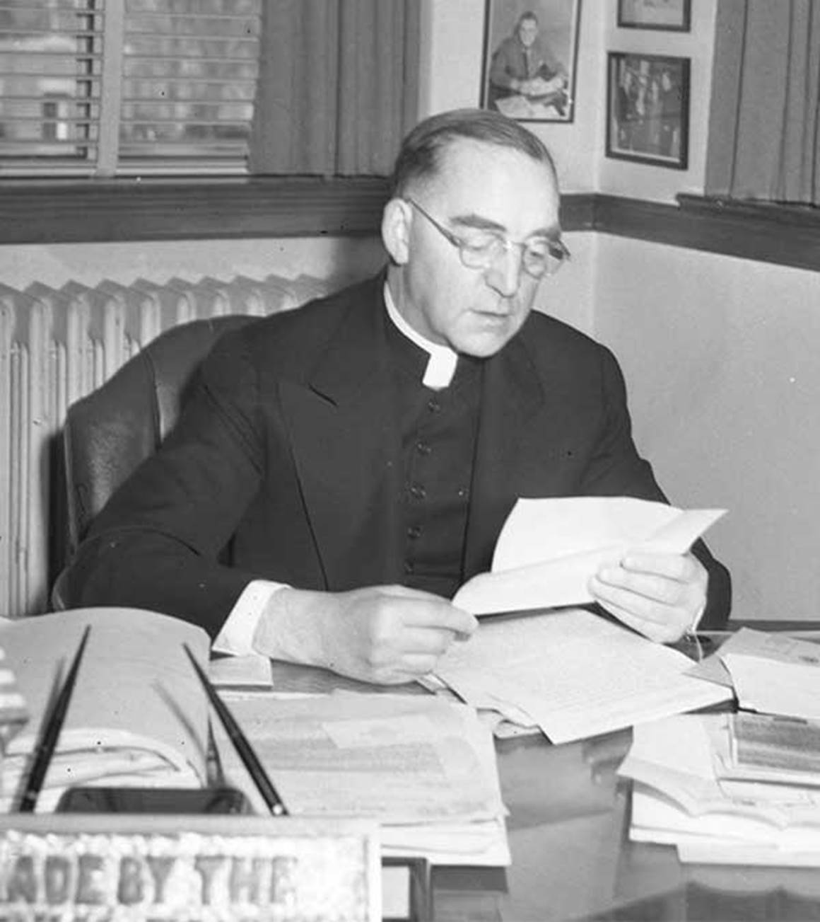 Father Flanagan reading letters at his desk