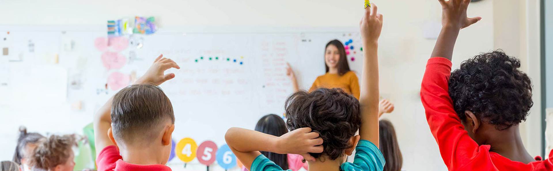 kids raising their hands in class