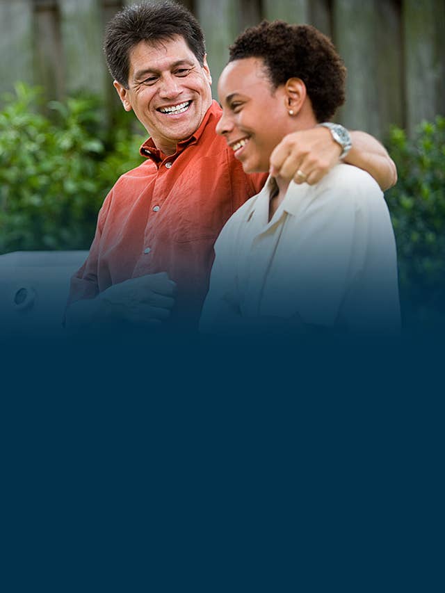 Man and young man hanging out, smiling on a bench