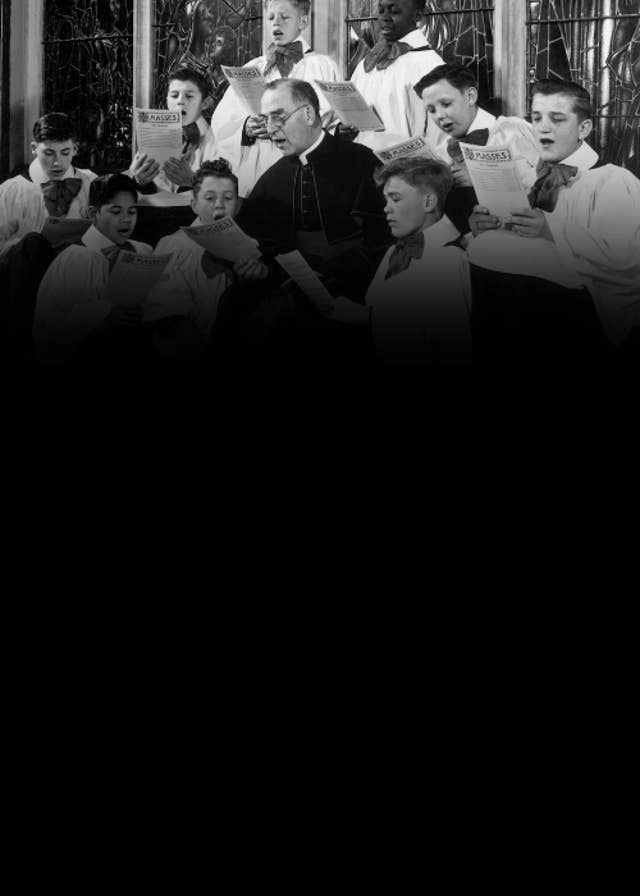 Father Flanagan singing with the choir