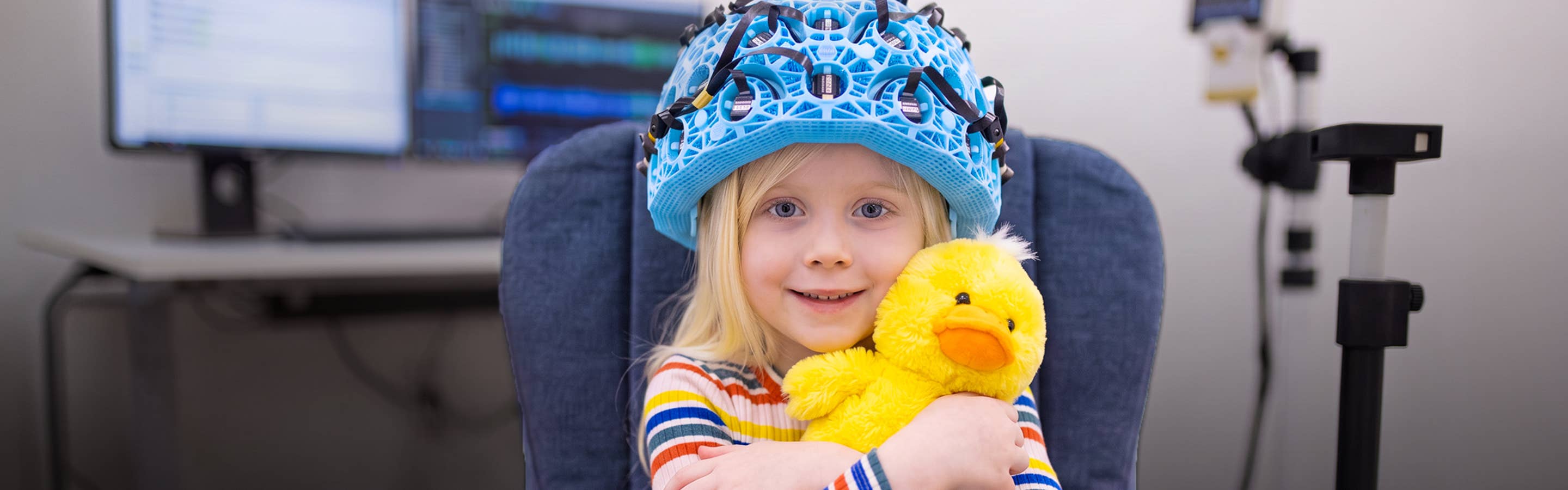 Young girl in MRI helmet with a rubber duck