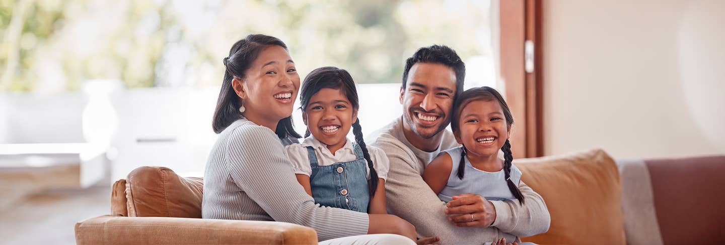 Family sitting on couch smiling