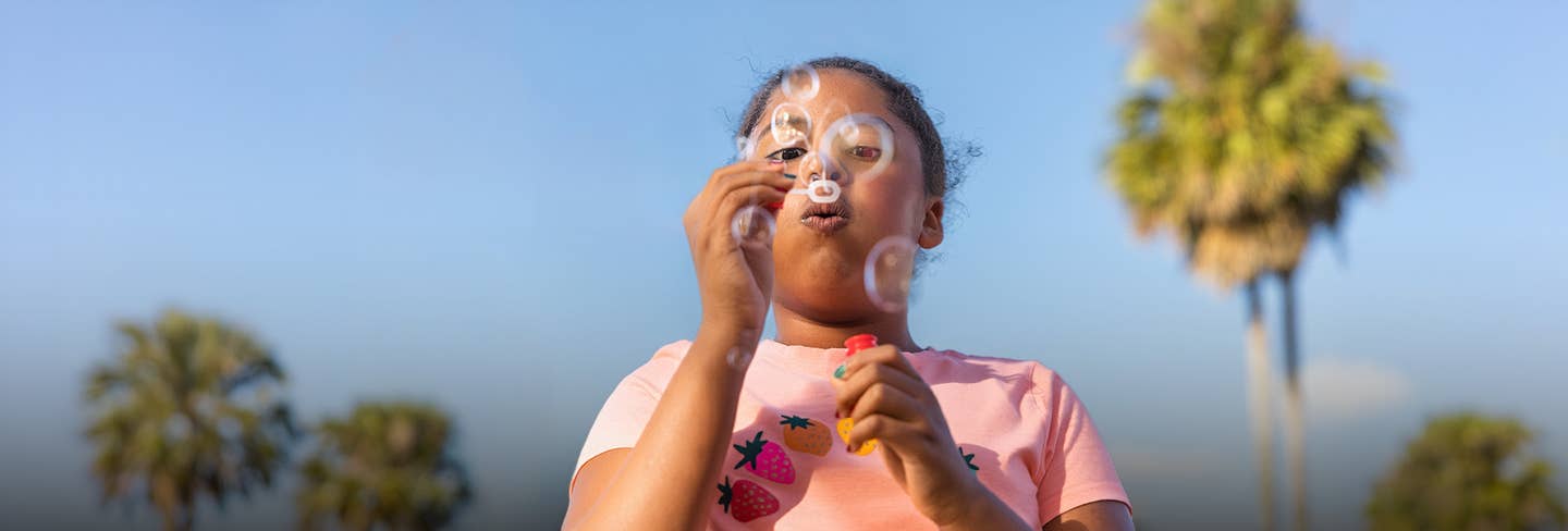 Girl blowing bubbles on a summer day