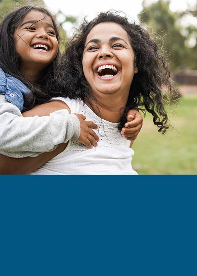 Mom giving her daught a piggy back ride