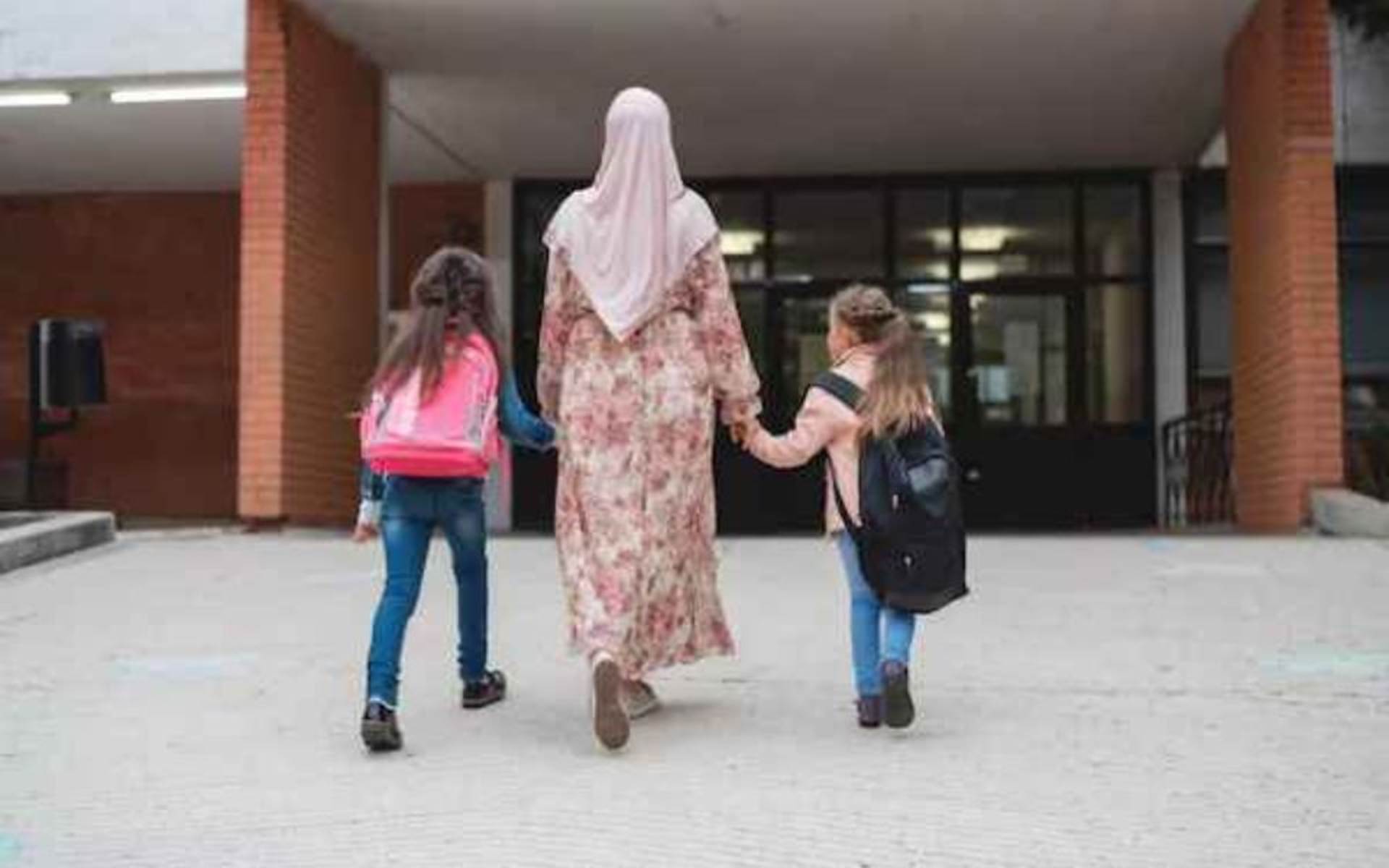 Mom with her 2 children walking into school