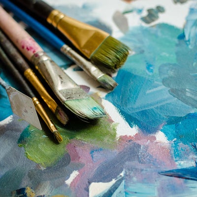 paint brushes next to a painting