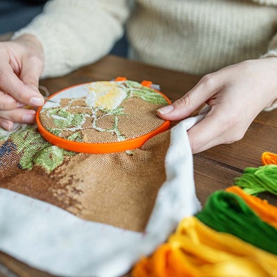 person teaching embroidery