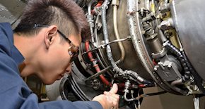 Student working on a plane engine