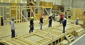 Group of carpenters building a house frame