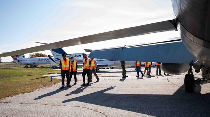 Large plane with students standing around it 