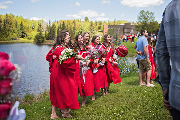 Canadore Students on graduation days standing by the pond