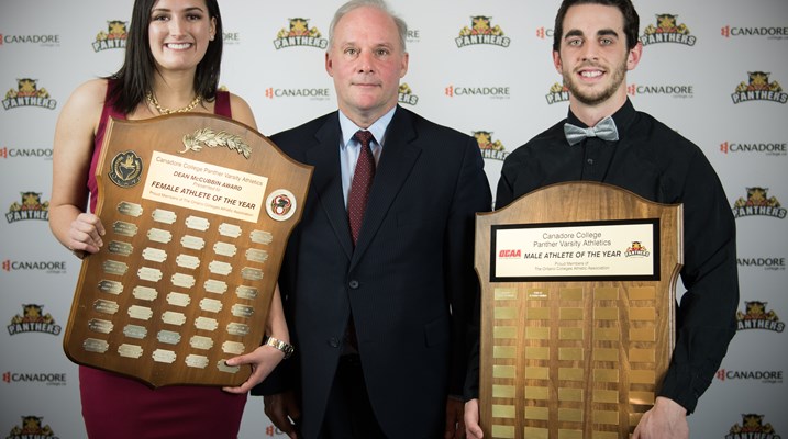 Two students winning an award with the college president