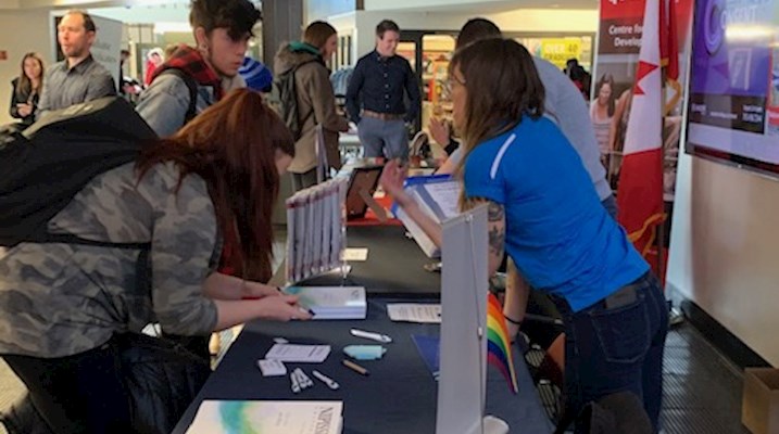 Students standing at a booth 