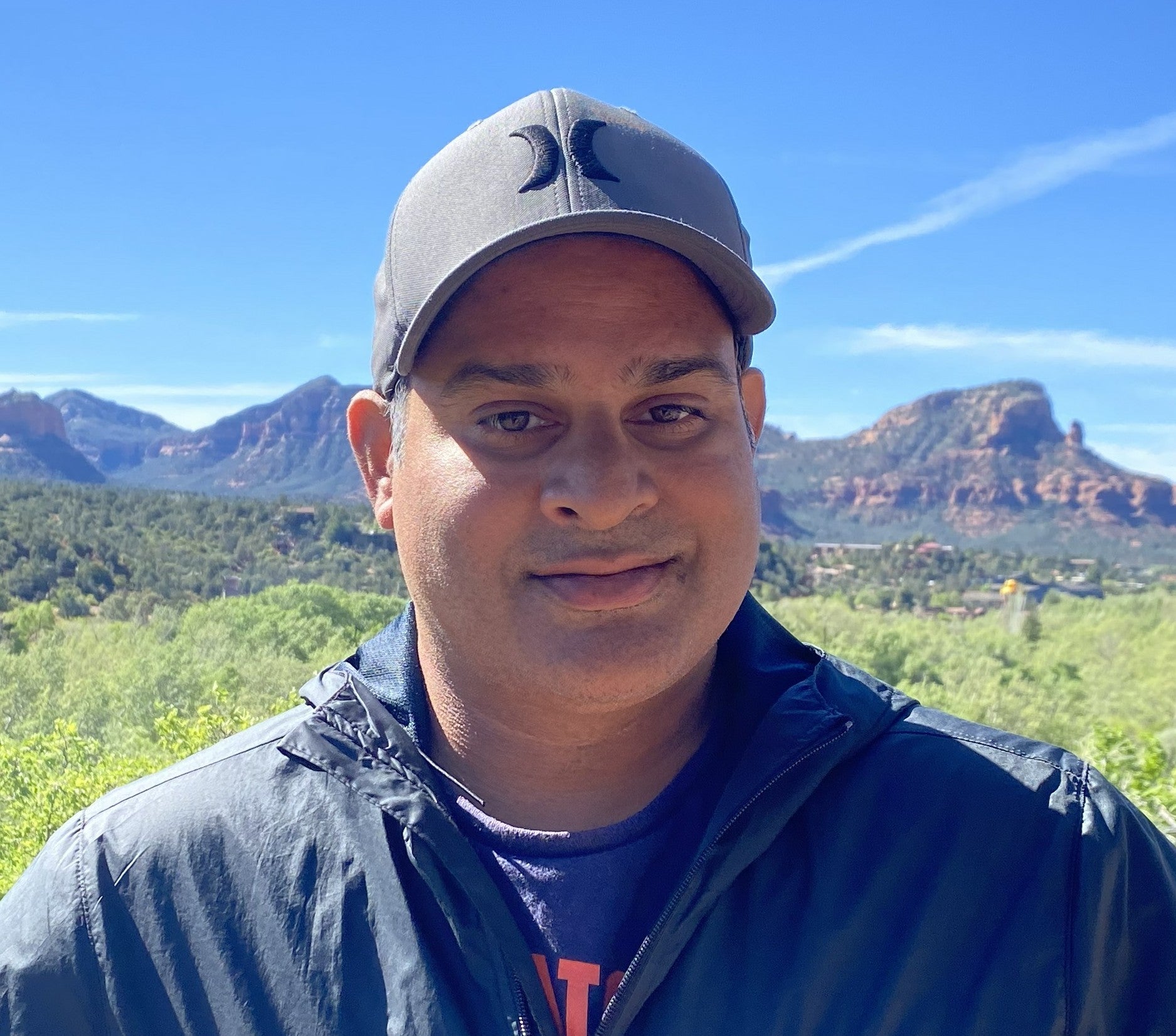 man in hat with blue sky and mountains
