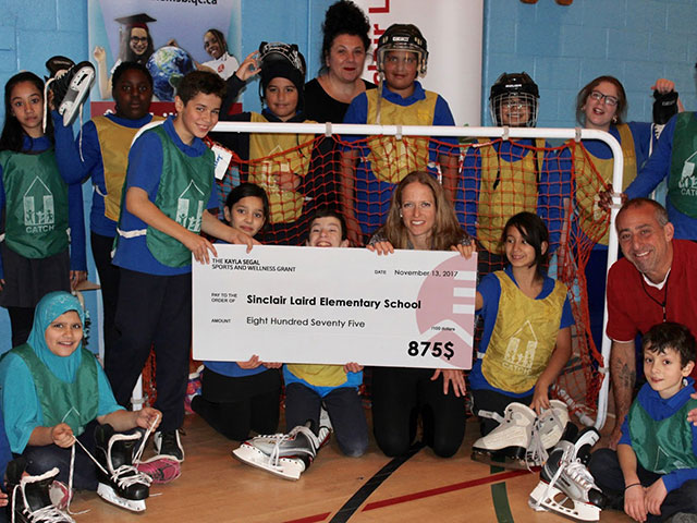 a groups picture of students and their teachers with a big cheque