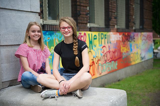 Willingdon students sitting next to mural