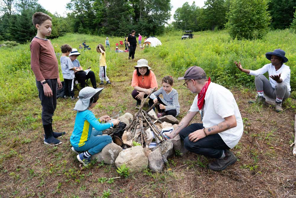 Youth at Giant Steps Forest School learn how to make a fire with Thomas Henderson