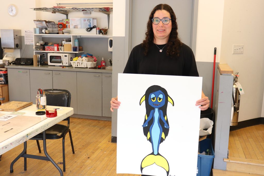 Artist from the Art Seen program, Jessica Teixeira-Pinto, at the Visual Arts Centre in Montreal’s Westmount on Nov. 25, 2024. She holds up a sketch of the puppet she will create, her dream is to be an artist like Jim Henson who created The Muppets. (Pamela Pagano, CityNews) 