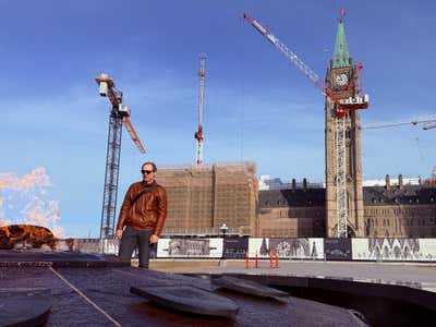 Standing near the Centennial Flame with Parliament Hill under construction behind