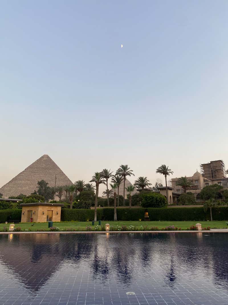 The hotel pool with the Great Pyramid at dusk