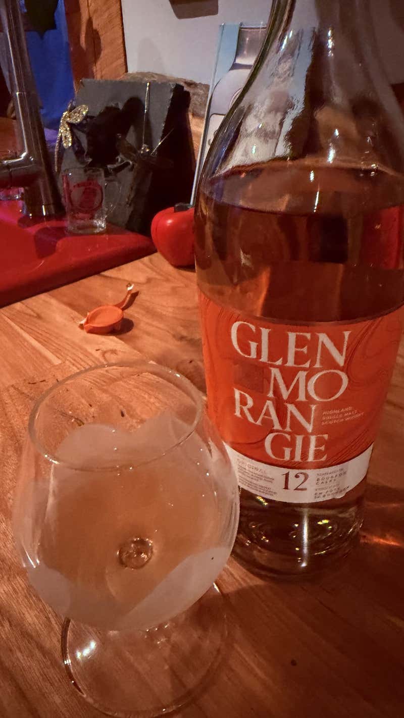 A bottle of Glenmorangie 12 and a glass on the counter