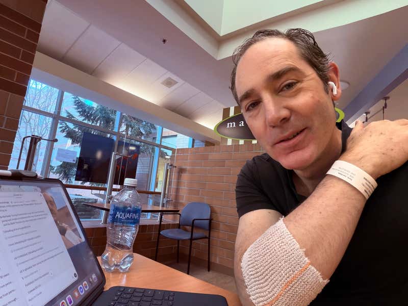 Waiting between tests at the hospital — wristband on, iPad out, choosing to be present for all of it