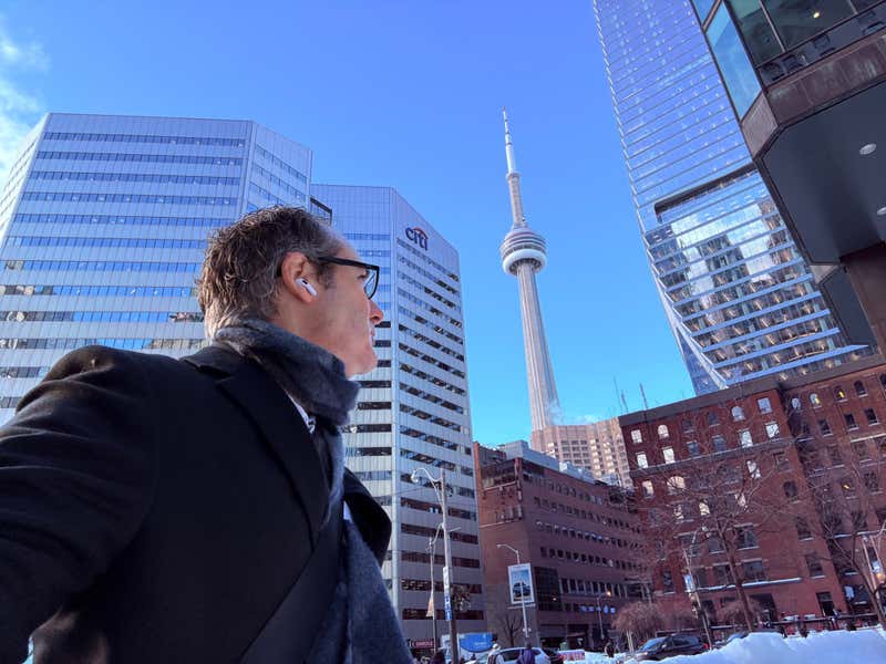 Joel walking to work in downtown Toronto, with the CN Tower in the background