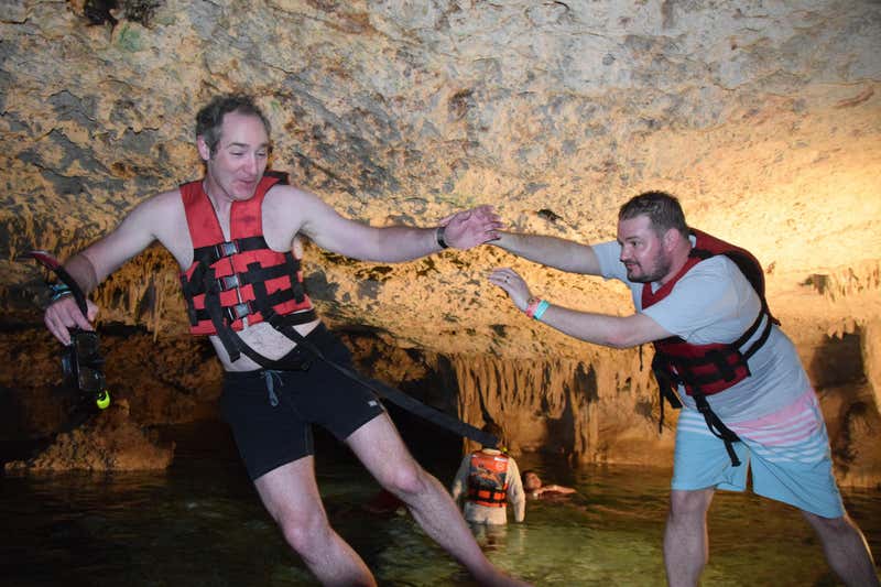 Helping each other navigate the slippery rocks inside the cenote