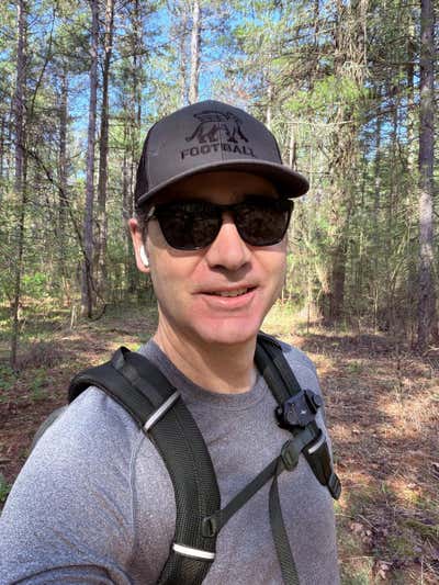 On the trail in the Football cap, Peak Design clip on the strap