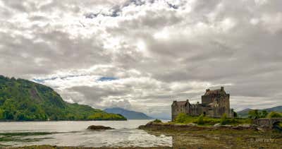 Eilean Donan Castle across the loch with broken cloud over the Highlands