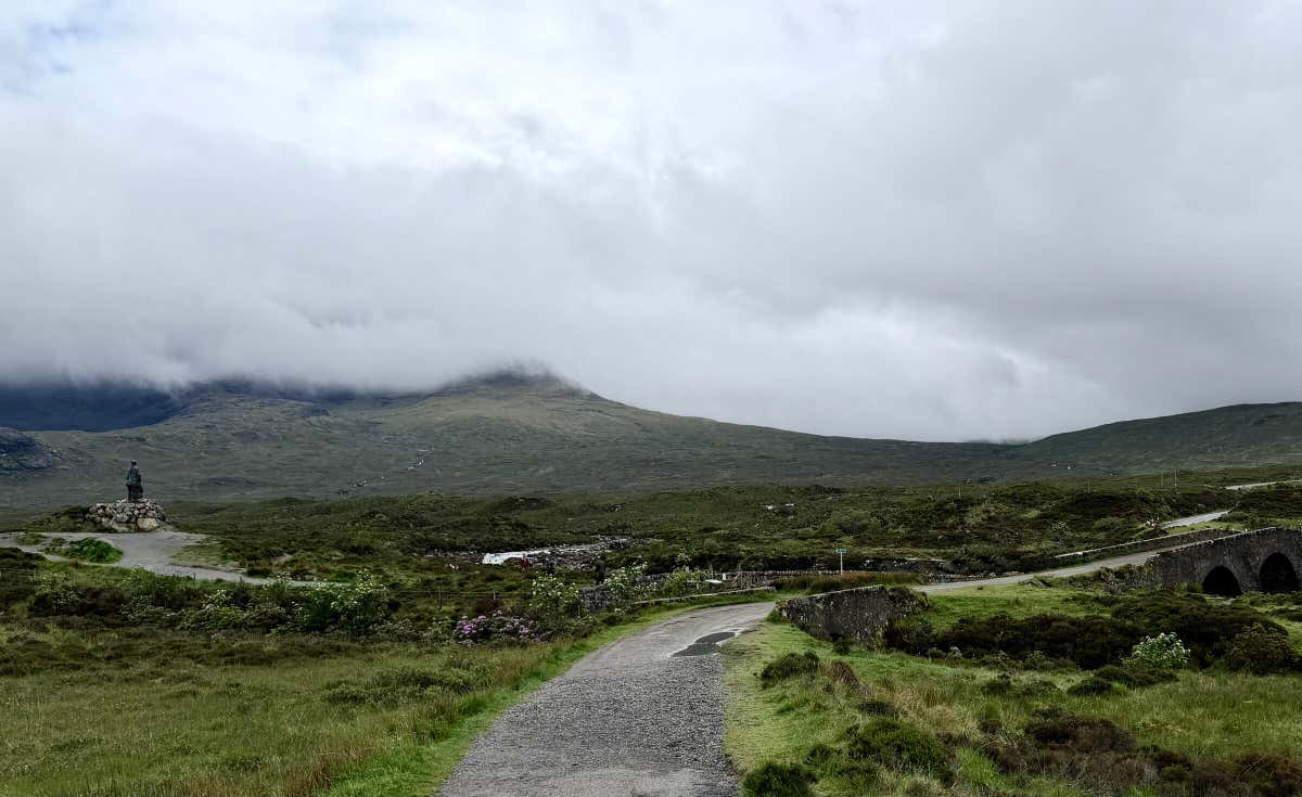 Leaving Sligachan past the climbers' statue, the old arched stone bridge over the river on the right and the Black Cuillin lost in cloud beyond