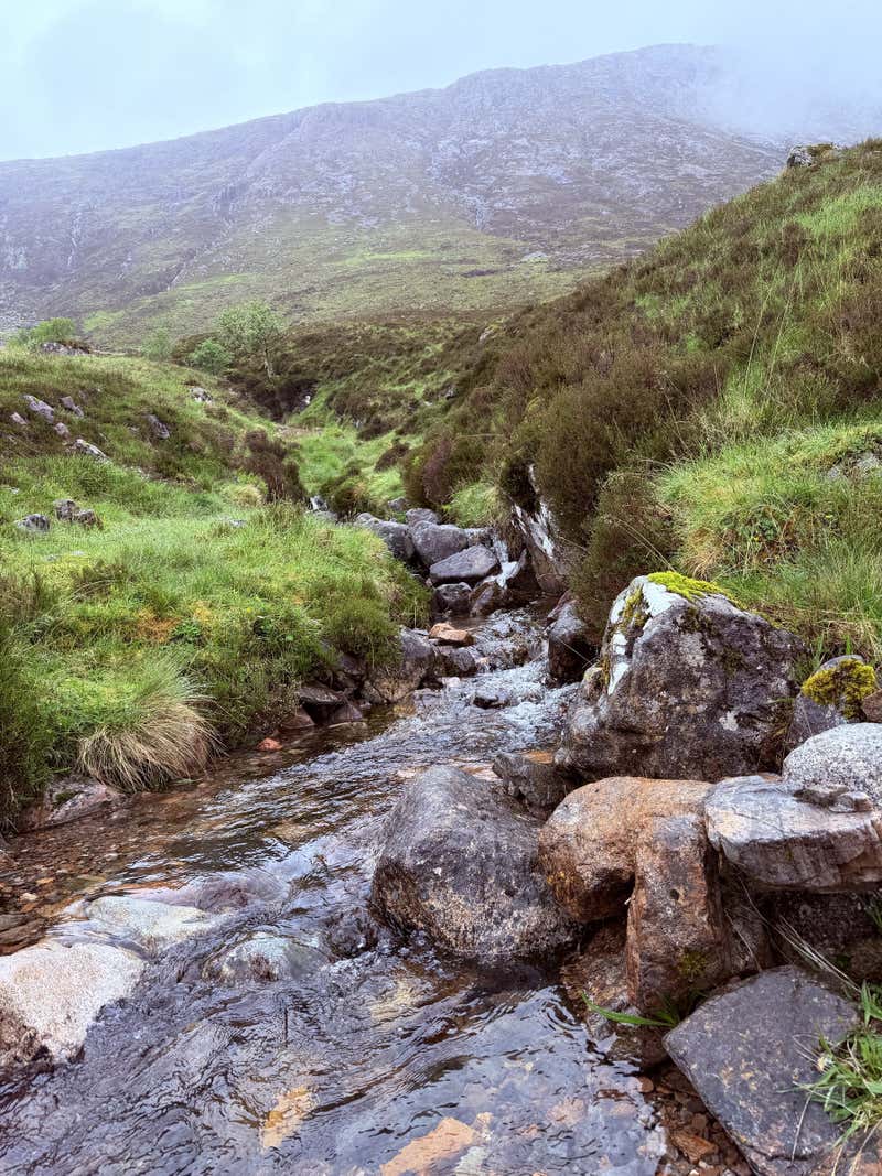 Looking down over a burn and the mist sitting in the valley below