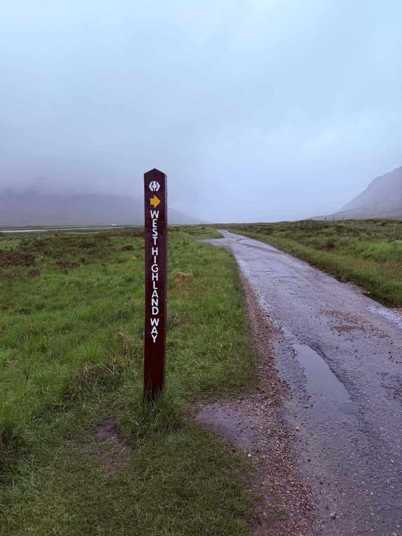 One of the West Highland Way markers, white symbol on dark wood