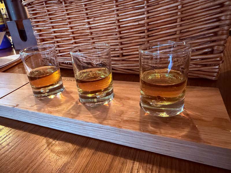 The Highland Mixture lined up, three drams on the wooden board
