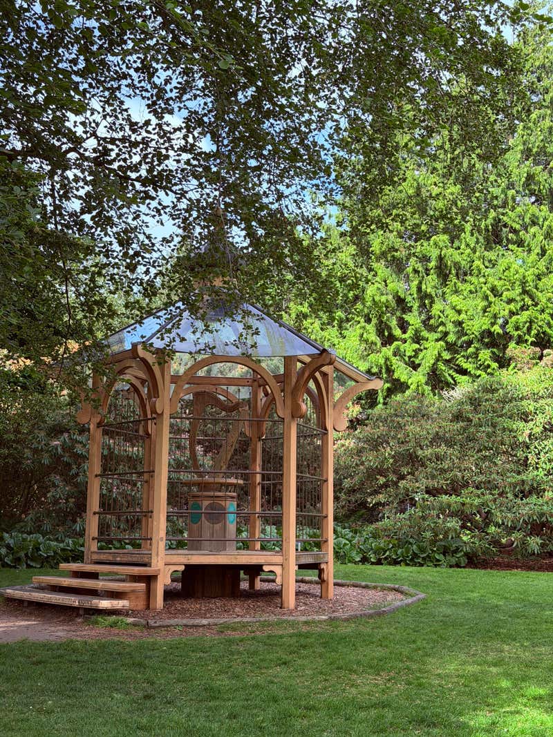 A wooden gazebo tucked into the green
