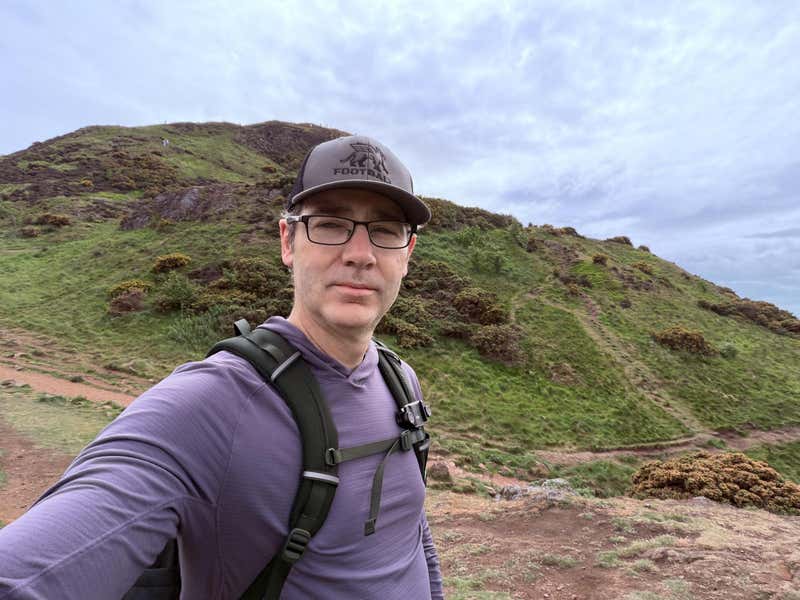 Catching my breath on the way up, the green slope of Arthur's Seat behind me