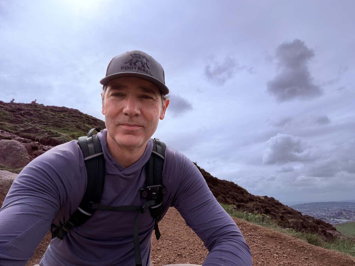 Selfie near the top of Arthur's Seat, Edinburgh stretching out along the ridge behind
