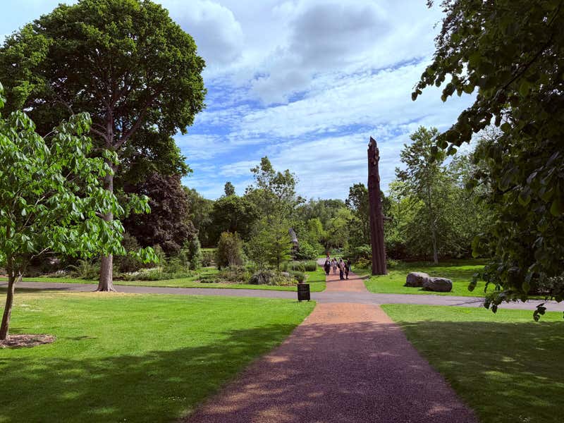 The path opening up past a tall carved sculpture