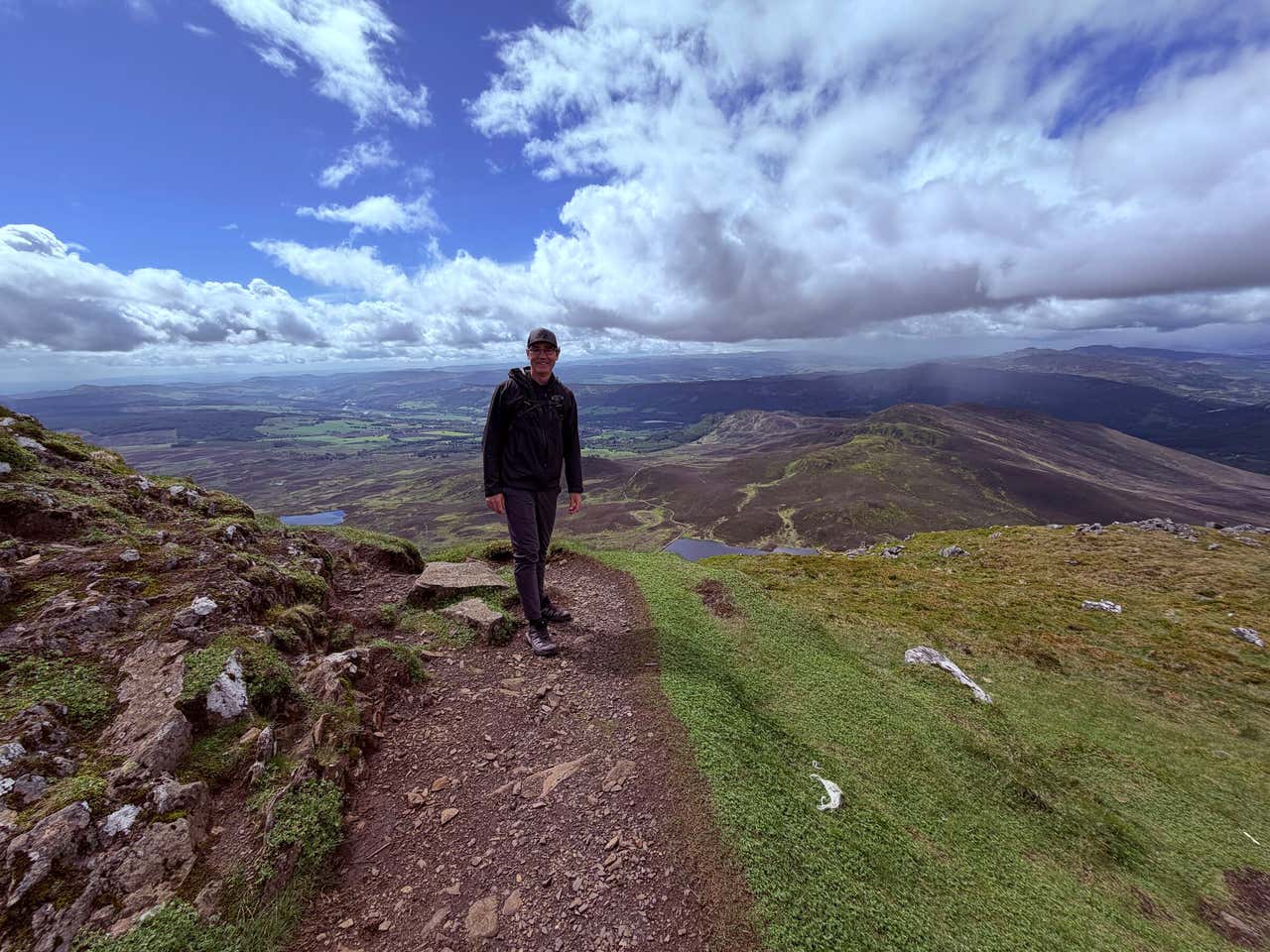 Joel on a Scottish summit, glen and lochs behind