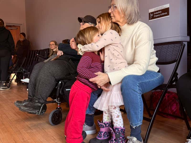 Val's grandchildren snuggled up together, taking in the rehearsal