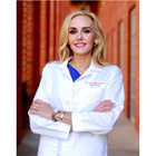 Katherine Pannel stands in front of red brick with arms crossed in her white coat. 