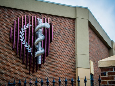 Image of KCU Crest sign on outside of building