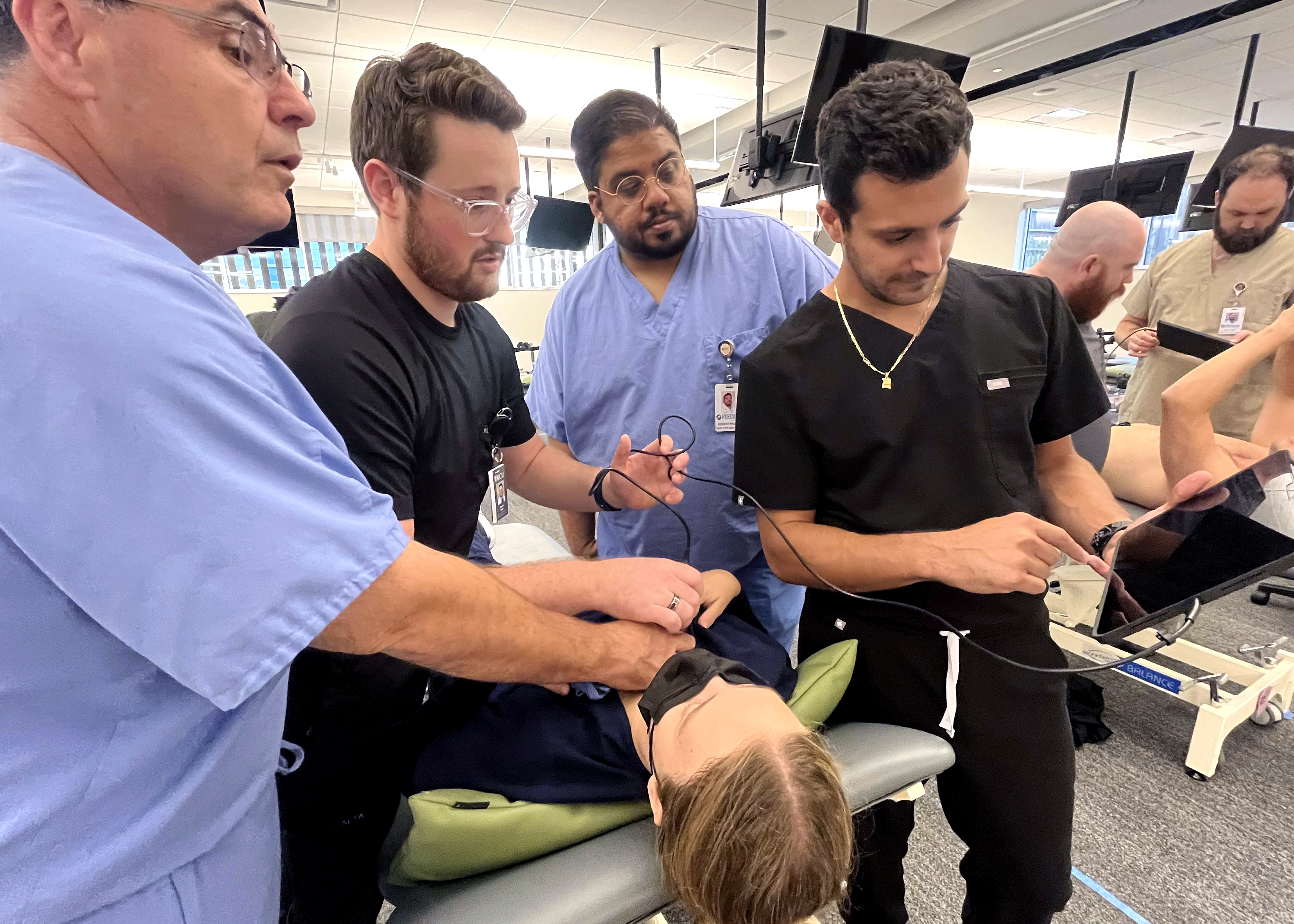 Three students and a professor test out new Butterfly ultrasound. 