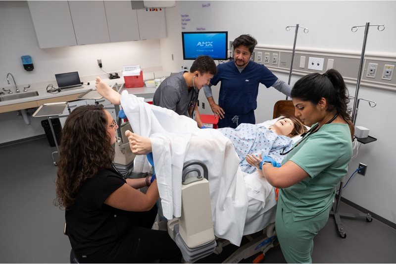 Students working with a medical manikin