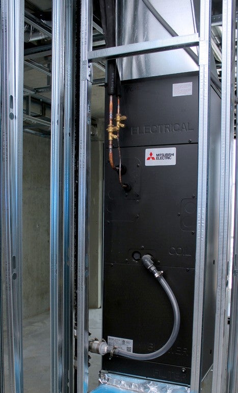 Mitsubishi Electric VRF indoor unit installed behind wall framing at Aquabella waterfront condos in Toronto.