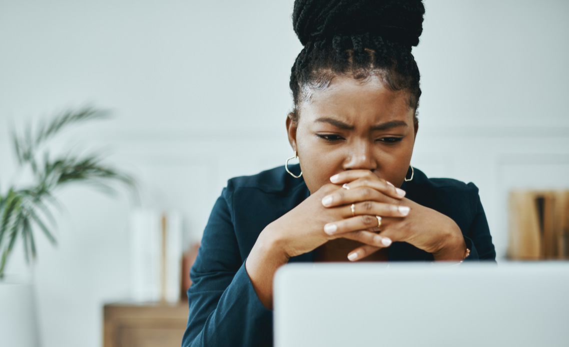 Illustration: Woman with concerned look in front of a computer. 